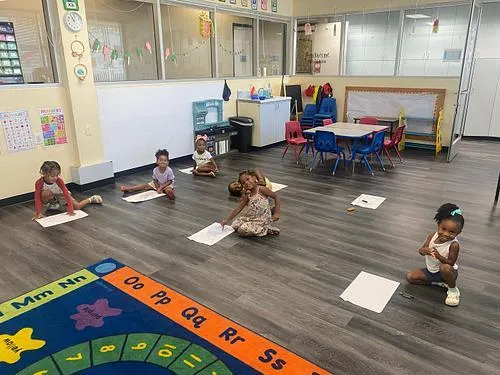 A KidsWay classroom with students learning on the alphabet rug